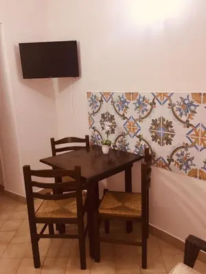 a dining room table with two chairs and a tv at Normanni Central House in Palermo