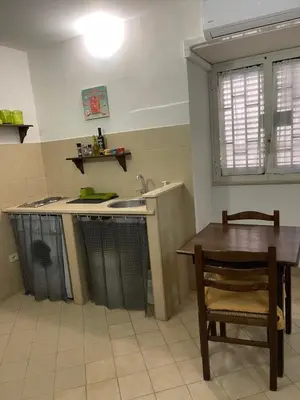 a kitchen with a table and a sink and a table and chair at Normanni Central House in Palermo