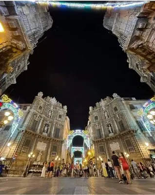 a group of people standing in front of two large buildings at Normanni Central House in Palermo