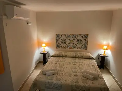 a bedroom with a bed and two lamps on two tables at Normanni Central House in Palermo