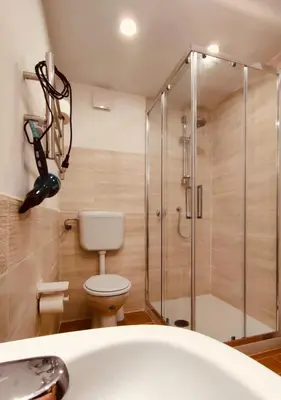 a bathroom with a shower and a toilet and a tub at Normanni Central House in Palermo
