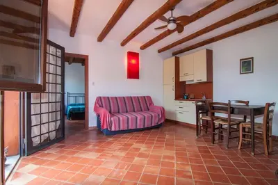 a living room with a red couch and a table at Il Casale il Sole e la Margherita in Campofelice di Roccella