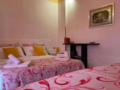 a room with two beds and a table at Un Nido Tra Mare e Monti in Partinico