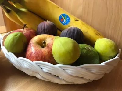 a basket of fruit with apples and bananas on a table at Un Nido Tra Mare e Monti in Partinico