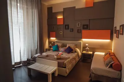 a bedroom with a large bed and a chair at Gran Cancelliere Apartment Parking in Palermo