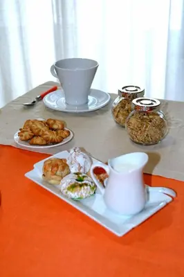a table with a plate of food and a cup of coffee at Gran Cancelliere Apartment Parking in Palermo