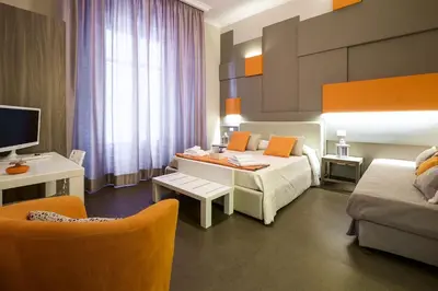 a hotel room with a bed and a table and chairs at Gran Cancelliere Apartment Parking in Palermo