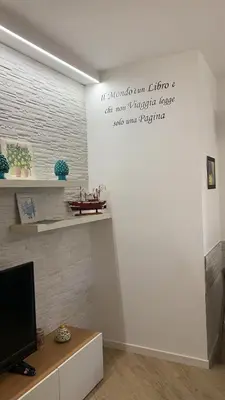 a living room with a tv and a white wall at LIBERTYHOUSE in Palermo