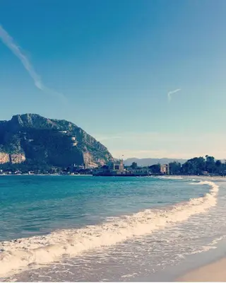 a view of a beach with a mountain in the background at LIBERTYHOUSE in Palermo
