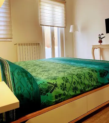a bedroom with a bed with a green comforter at casa vacanze Sleep Art in Palermo