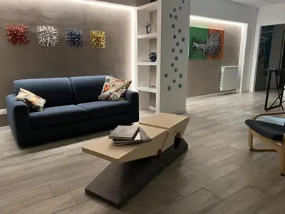 a living room with a blue couch and a table at casa vacanze Sleep Art in Palermo