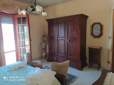 a bedroom with a large wooden cabinet and a bed at Casa vacanze a Serra Scirocco in Trabia