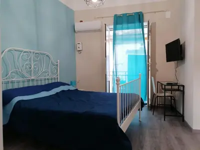 a bedroom with a blue bed and a window at La terrazza sul vicolo in Palermo