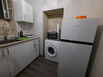 a kitchen with a refrigerator and a washing machine at La terrazza sul vicolo in Palermo