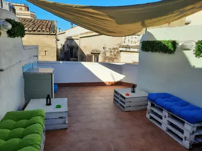 a rooftop patio with a canopy and benches on a building at La terrazza sul vicolo in Palermo