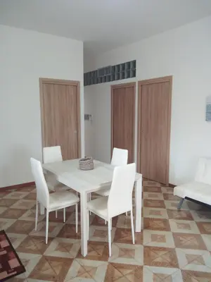 a white dining room with a white table and white chairs at Appartamento a Mondello in Mondello