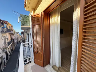 a balcony with a wooden door on a building at Made In Sicilia -IN CENTRO, ARIA CONDIZIONATA e NO ZTL- CITY CENTRE, AIRCON and NO LTZ in Castellammare del Golfo