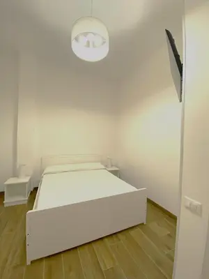 a white bedroom with a white bed and a light at Medusa -IN CENTRO, ARIA CONDIZIONATA e NO ZTL -CITY CENTRE, AIRCON, NO LTZ in Castellammare del Golfo