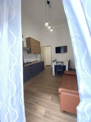 a living room with a couch and a kitchen at Medusa -IN CENTRO, ARIA CONDIZIONATA e NO ZTL -CITY CENTRE, AIRCON, NO LTZ in Castellammare del Golfo