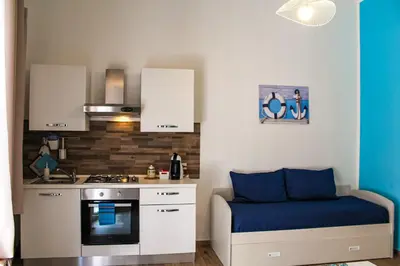 a small kitchen with a bed and a stove at Casa Turà in Isola delle Femmine