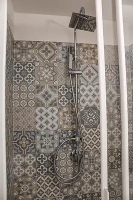 a shower in a bathroom with a tile wall at Casa Turà in Isola delle Femmine