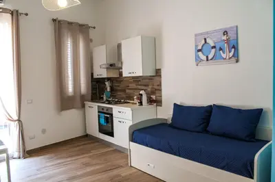 a small room with a bed and a kitchen at Casa Turà in Isola delle Femmine