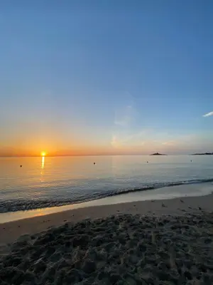 a sunset over the ocean with a sandy beach at Casa Turà in Isola delle Femmine