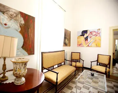 a living room with three chairs and a table at CUBA'S ART HOUSE in Palermo