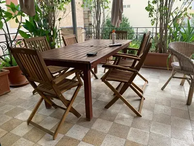 a wooden table and chairs on a patio at CUBA'S ART HOUSE in Palermo
