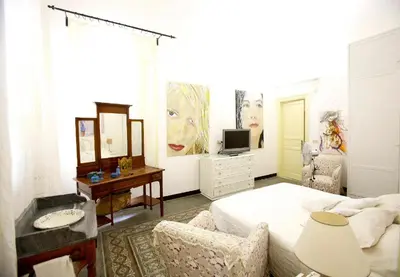 a bedroom with a bed and a desk and a tv at CUBA'S ART HOUSE in Palermo
