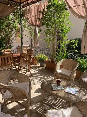 a patio with chairs and tables and an umbrella at CUBA'S ART HOUSE in Palermo
