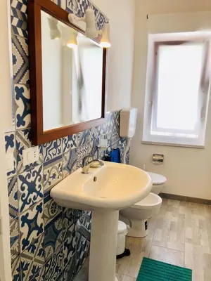 a bathroom with a sink and a toilet and a mirror at VILLA OASI a 50 mt dalla spiaggia in Alcamo Marina