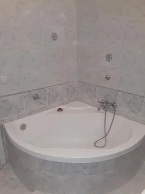 a bath tub in a bathroom with a stone wall at Franco-Home in Palermo