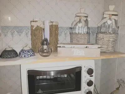 a shelf with glass jars and a microwave on it at Franco-Home in Palermo