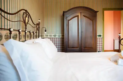 a bed with white sheets and a wooden headboard at Solemar Sicilia - Villa Anastasia in Ficarazzi