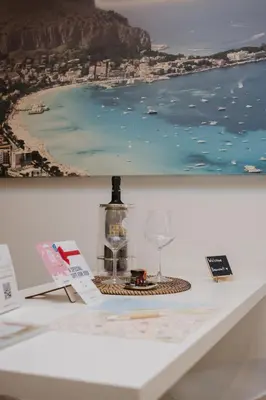 a table with two glasses and a picture of the ocean at Paccamora by Maravigghia Palermo in Palermo