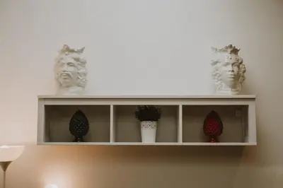 a white shelf with three statues on it at Paccamora by Maravigghia Palermo in Palermo