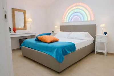 a bedroom with a bed with a rainbow on the wall at Paccamora by Maravigghia Palermo in Palermo