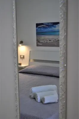 a mirror with two towels sitting on a bed at Casa Vacanze Monte Cofano in Macari