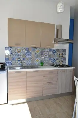 a kitchen with blue and white tiles on the wall at Casa Vacanze Monte Cofano in Macari