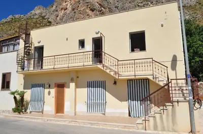 a building with stairs in front of a mountain at Casa Vacanze Monte Cofano in Macari