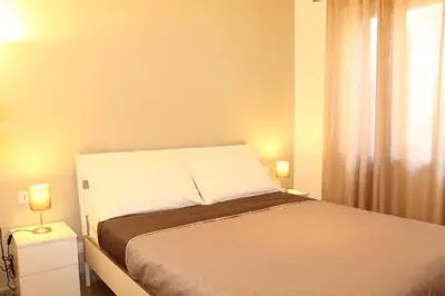 a bedroom with a bed with two lamps on two tables at Cosmo Apartment in Palermo