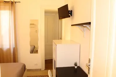 a small room with a bed and a white refrigerator at Cosmo Apartment in Palermo