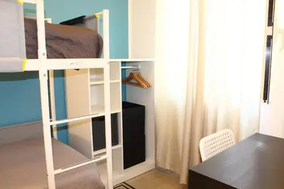 a room with a bunk bed and a desk at Cosmo Apartment in Palermo