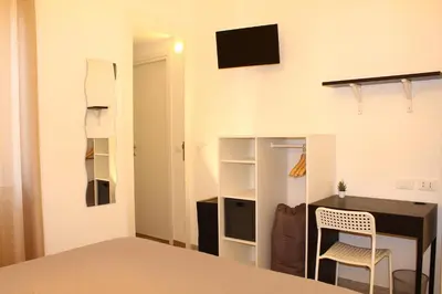 a bedroom with a bed and a desk with a computer at Cosmo Apartment in Palermo
