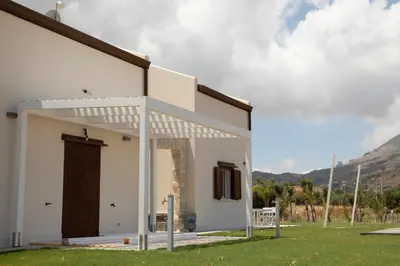a white house with a large door on the side at Villa NATURE ZAGARA SCOPELLO ZINGARO in Castellammare del Golfo