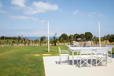 a white table and chairs in a field at Villa NATURE ZAGARA SCOPELLO ZINGARO in Castellammare del Golfo