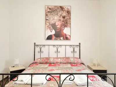 a bedroom with a bed with a picture on the wall at Villa Mazzamuto in Altavilla Milicia