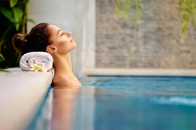 a woman laying on the floor next to a swimming pool at Principe Alogna Hotel & SPA in Altavilla Milicia