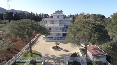 a large white house with trees in front of it at Principe Alogna Hotel & SPA in Altavilla Milicia